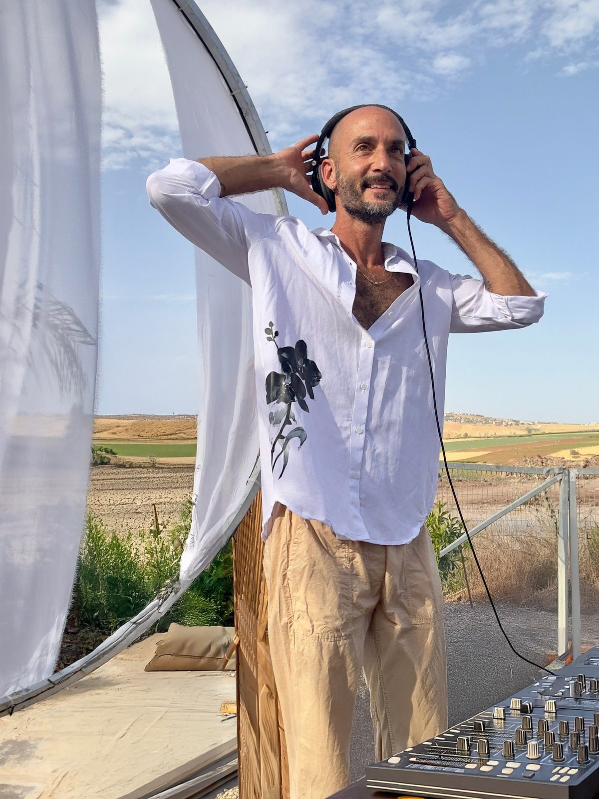 Leroy עם אוזניות וחיוך באירוע חוץ